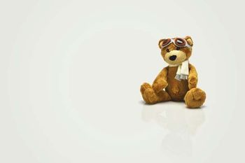 A brown teddy bear wearing aviation goggles.